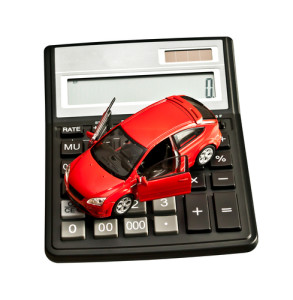 Toy car and calculator over white. Rent, buy, repair or insuranc